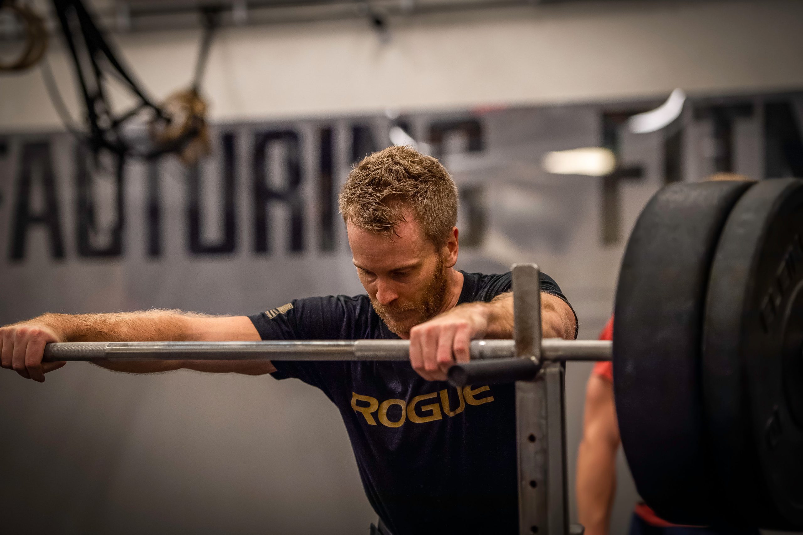 Kille med lastad skivstång i squat racket.