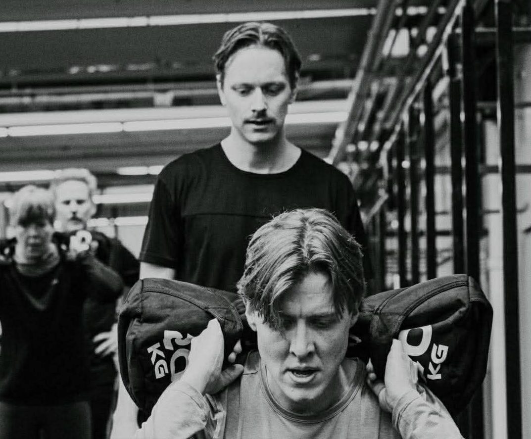 Kille som går utfallsteg med en sansäck på axlarna.